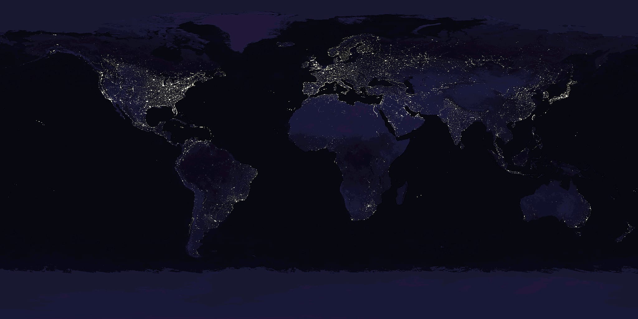 The Earth at night, lit by cities across every continent